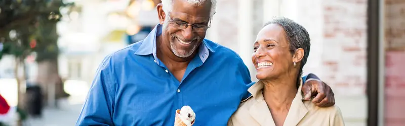 An older couple walking together on a city street