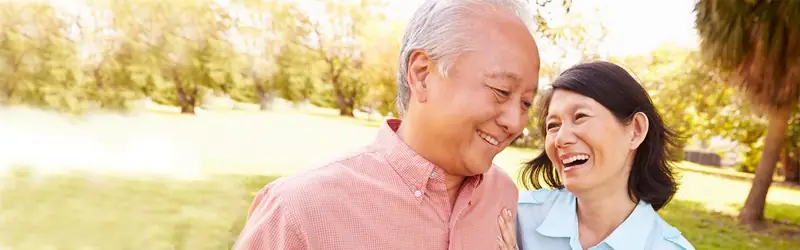 An older couple smiling together outdoors