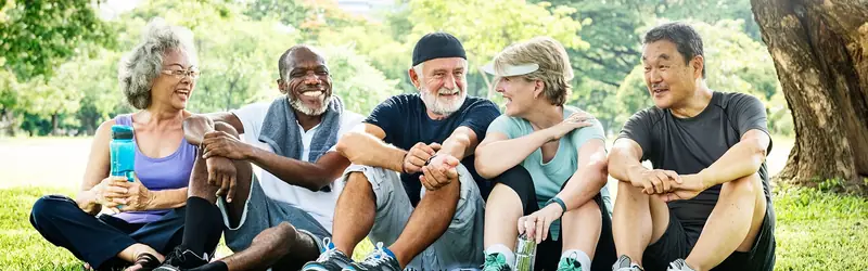 Older friends relaxing together on the grass
